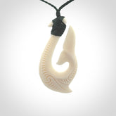 A handcarved hook pendant with a whaletail end. This is carved from bone and is detailed with a traditional Maori engraved design. We will ship this piece to you anywhere in the world and the price for shipping is included in the price. Unique bone jewellery for sale online at www.nzpacific.com